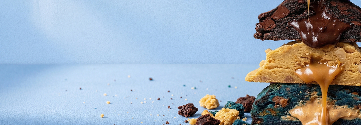 Stack of cookies with chocolate and caramel on a blue background