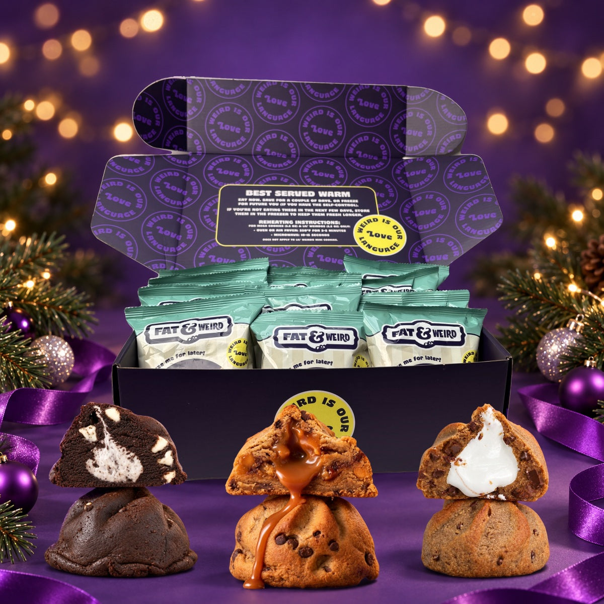An open Fat & Weird box of wrapped cookies with stuffed cookies cut open in front, holiday greenery around it