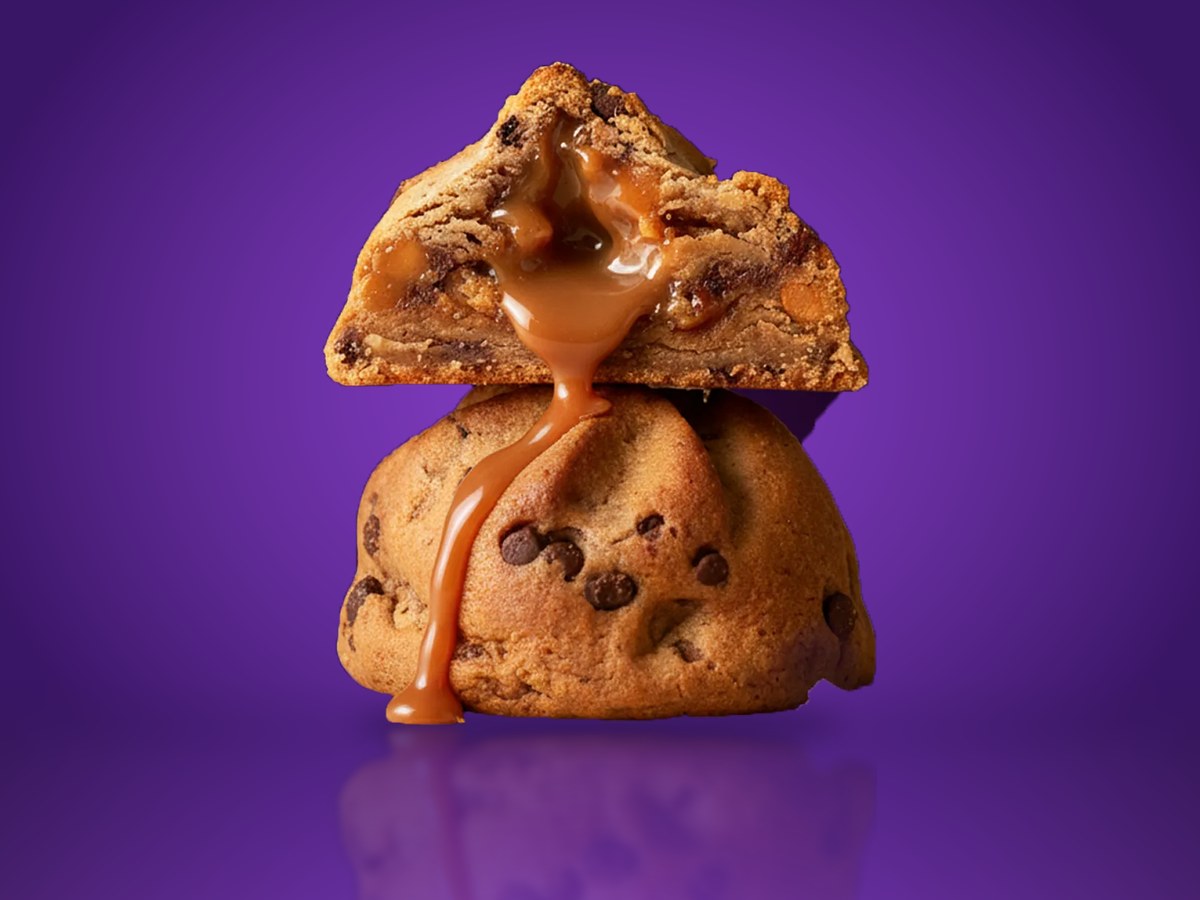 A Fat & Weird stuffed cookie with its caramel center showing, on a purple set